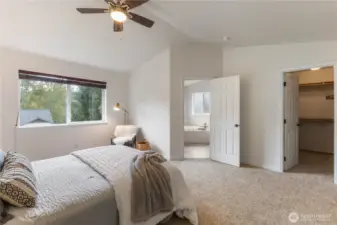 The primary bedroom has vaulted ceilings, an en suite bathroom, and a walk-in closet.