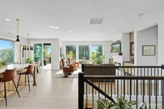 Kitchen with eating space at the island and at the dinner table combines with the great room and fireplace.  Access to the upper level deck is through the sliding doors.  Access to walk out first floor is down the stairs.