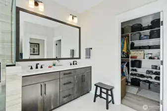 Double sinks and large mirror in the primary bathroom along with a walk-in closet.