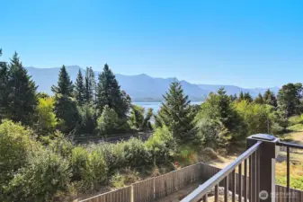 View off the back deck to the back yard, trees, river and mountains!