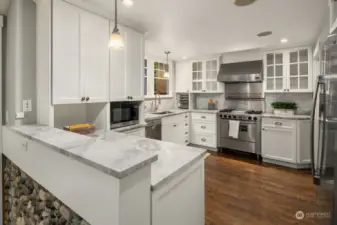 Chef inspired kitchen with walk-in pantry, stainless steel appliances, quartz counters and shaker style cabinets.