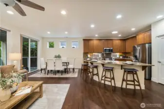 The large Quartz kitchen island makes for a great gathering spot for friends and family.  Timeless 42" cabinets, full height backsplash & SS appliances.  Ample dining area overlooking the permanent greenspace. Plus, mature arborvite provide even more privacy!