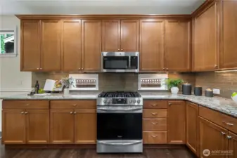 Stunning kitchen with Quartz counters, timeless cabinetry, full height backsplash and plenty of storage.