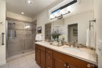 Primary bath with Quartz counters, tile flooring and a fully tiled shower.