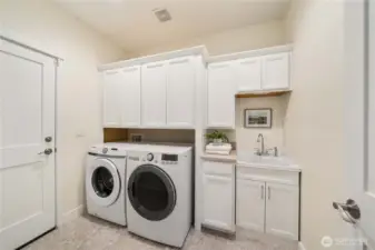 Laundry/mud room off of the garage with storage and a convenient sink.