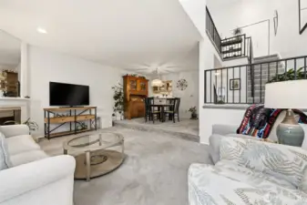 View from patio doors looking at dining area and stairway. Open and bright. Great space to relax/entertain.