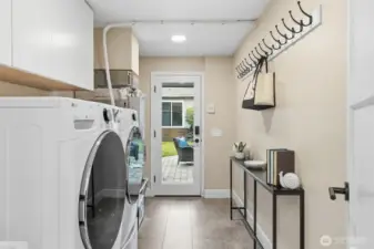Spacious laundry room with extra storage and backyard access