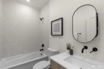 The lower-level guest bath features a full bathtub, granite counters and luxury black matte hardware package.