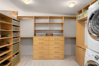 Custom walk-in closet features a washer/dryer and new carpet.