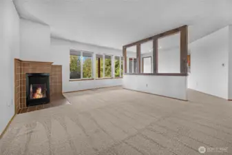 The living room/dining room features a wall of windows flooding the rooms with natural light and offering views of the lake.