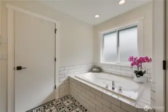 Soaking tub in primary suite.  Walk in shower to the right.