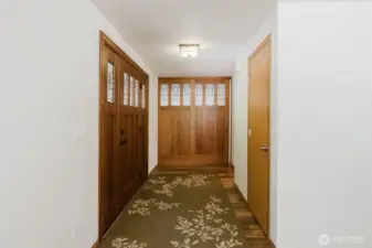 Entryway shows off the nod to the Craftsman vibe wth custom built doors that lead to the bonus room.  These cherry wood doors are floor to ceiling and are set on a sliding track to allow the broad doorway to be fully open as needed.