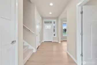 Open and inviting entryway! The front door with transom window above allows natural light to stream in and brighten the space