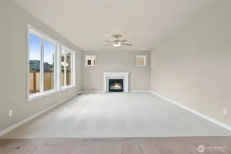 Spacious and inviting great room with a clean, modern design and gas fireplace including a ceiling fan.