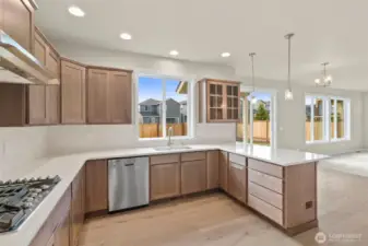 Kitchen opens into nook and a spacious living area with large windows creating a seamless flow ideal for both everyday living and entertaining.