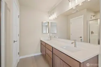 Primary bathroom with tile flooring and quartz countertops.