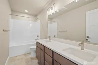 Main bathroom with dual sink vanity and quartz countertops.