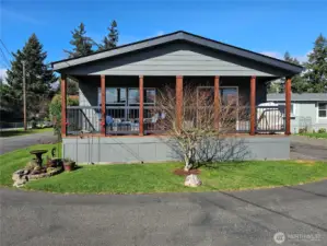 The front porch spans the entire width of the building with comfortable outdoor furniture and a BBQ which all stay with the home!