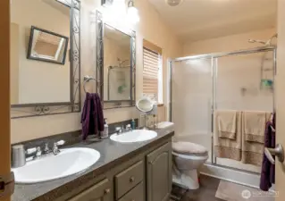 The primary bathroom features a double vanity and walk-in shower with seat.