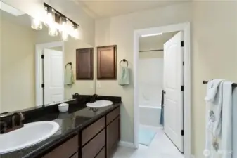 Well-appointed full bath with dual sinks and convenient shower/tub combo.