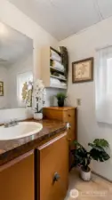 Partially updated bathroom has new flooring and toilet