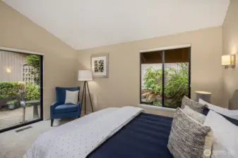 Another view of the primary bedroom, highlighting its tranquil setting and access to the back patio.