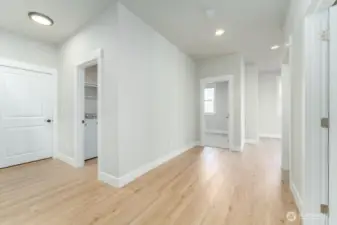 Downstairs hallway with garage and laundry room to the left, 2nd bedroom straight ahead and 3rd bedroom to the right.
