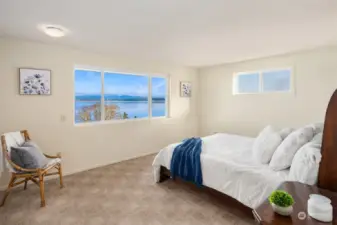 The main level primary bedroom offers stunning sound and mountain views overlooking Port Susan, creating a serene and picturesque retreat.  + 2 Dual Closets!