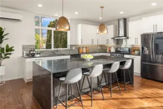 The center island features a waterfall design on the quartz counters and easily seats 4. High-end Bellmont cabinets are installed throughout the kitchen and home.