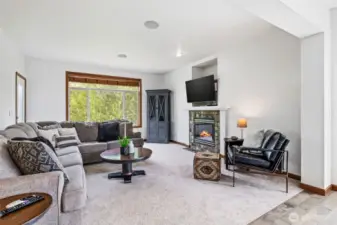 The open-concept family room features built-in audio, a cozy fireplace, and a convenient walkout to the side patio.