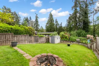 Well-kept yard with firepit.