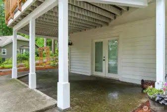 Covered front patio with door leading to primary bedroom