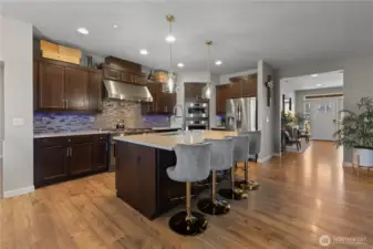 Large island with sink quarts counters tile backsplash new pendant lighting.