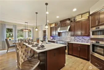 Large island with sink quarts counters tile backsplash new pendant lighting.