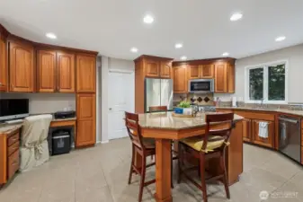 Well-appointed kitchen with warm fine-grain Lyptus hardwood cabinetry, center island, dedicated desk area and all new stainless steel appliances.