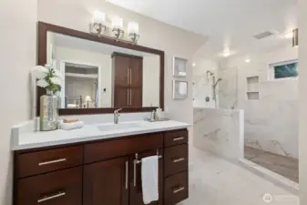 Spacious primary bathroom with dual vanity, large mirror, and bright, clean finishes.