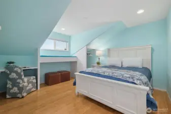 Charming bedroom with sloped ceilings and cheerful color palette.