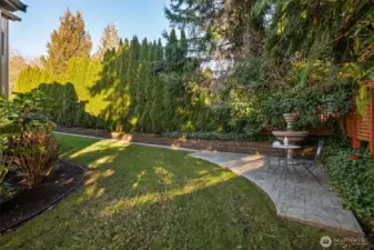 Peaceful backyard retreat with manicured lawn and garden pathways.
