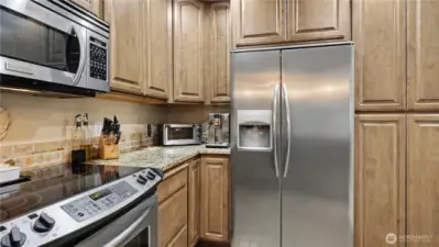 Granite countertops paired with a warm, complementary backsplash add timeless style to the kitchen.