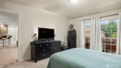Primary bedroom with sliding glass doors that open up to a private balcony, bringing in fresh air and natural light.