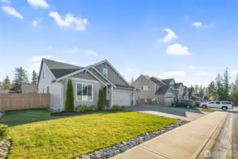 Positioned along a quiet residential street, this home showcases a wide lot frontage, sidewalk access, and a well-kept neighborhood setting. The exterior design blends seamlessly with surrounding homes.
