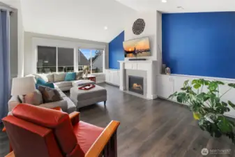 From this angle, the living room highlights built-in cabinetry and a central fireplace, offering both function and a natural focal point for the space.