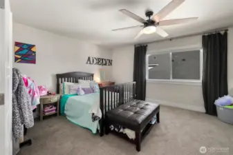 Spacious secondary bedroom with room for both sleeping and play, plus a large window that keeps the space feeling light and comfortable.