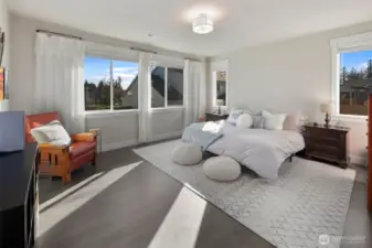 Spacious primary bedroom filled with natural light, offering plenty of room for a full furniture setup and a relaxing retreat feel.