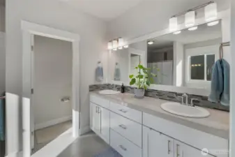 Spacious primary bathroom with dual vanities, modern finishes, and plenty of storage.