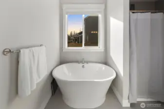 Spa-like soaking tub positioned beneath a window, perfect for relaxing at the end of the day.