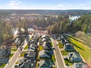 Bird’s-eye view of the neighborhood, showing nearby green space, water features, and a peaceful setting.