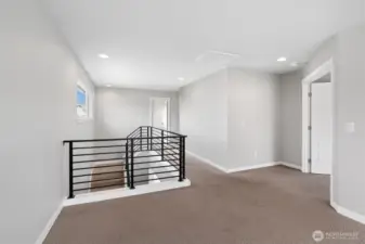 "Huge Bonus room" atop the stairs, with primary room entrance to the right.