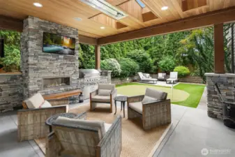 Covered outdoor living space with heaters, gas fireplace, built-in barbecue and TV