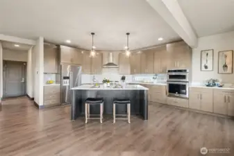 Spacious open-concept kitchen featuring a large island, abundant cabinetry, and seamless flow into the main living areas.